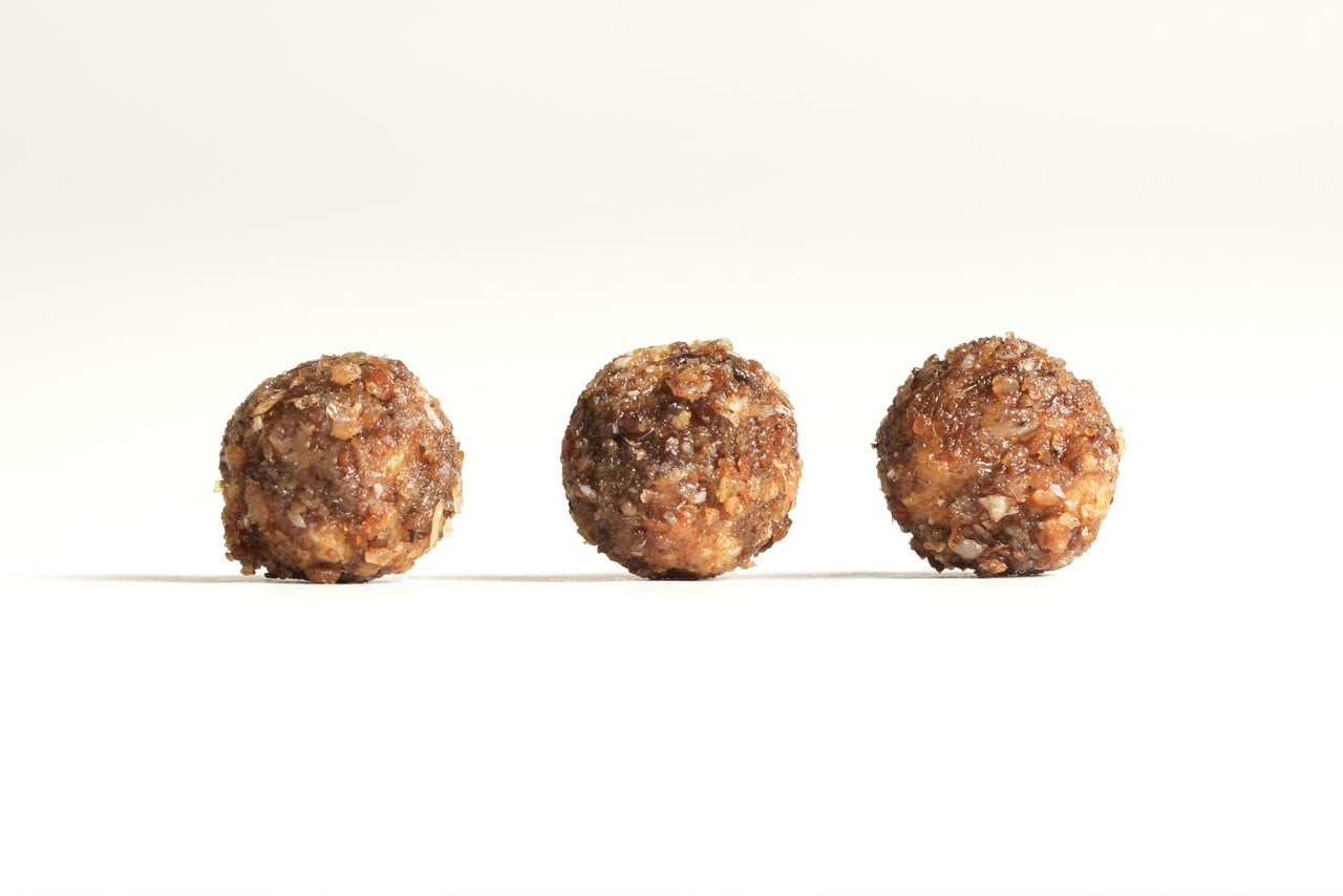 Trois croquettes alignées sur un fond clair